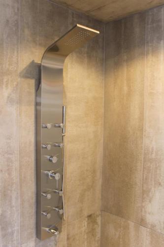 a shower with a metal rack on a wall at Don Gregorio Spa in Merlo