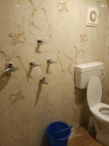 a bathroom with a toilet and pipes on the wall at BM Shaw Guest House in Kolkata