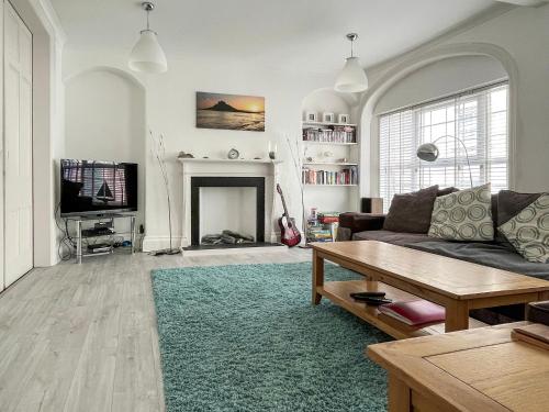 a living room with a couch and a fireplace at Seaglass in Marazion