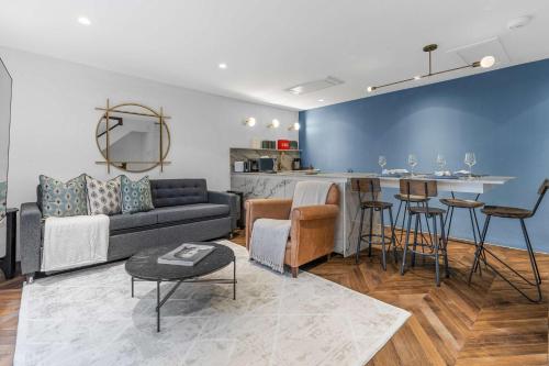 a living room with a couch and a kitchen at Contemporary 2-Bedroom Escape in Notting Hill in London