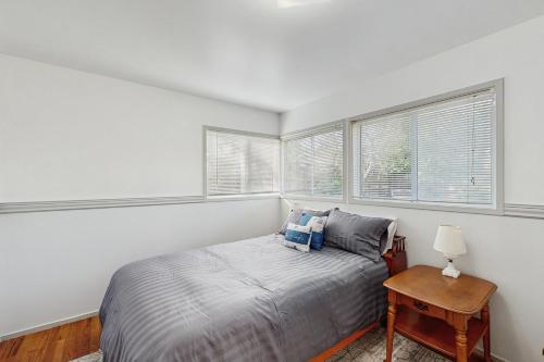 a bedroom with a bed and two windows at West End Wanderlust in Eureka