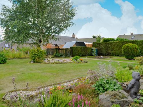 a garden with a statue in the middle of a yard at Laurel Bank in Alyth