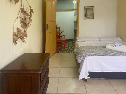 a bedroom with two beds and a wooden table at kitnet no Centro histórico in São João del Rei