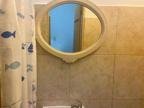 a bathroom with a mirror and a shower curtain at kitnet no Centro histórico in São João del Rei