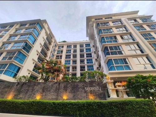 two tall buildings with trees in front of them at Apartment Serenity Wongamat in Pattaya North