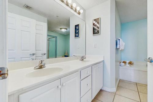 a white bathroom with a sink and a mirror at Summerwind West 0704 in Navarre