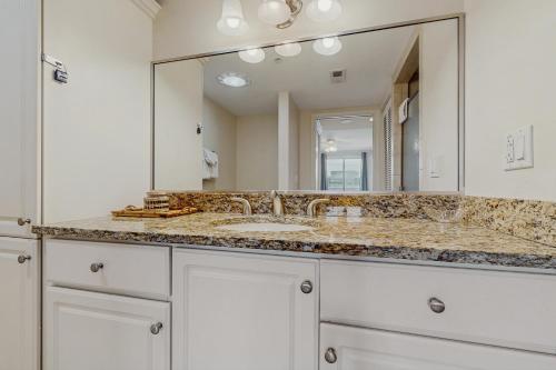 オーシャンシティにあるMakai 108の洗面台と大きな鏡のあるバスルーム