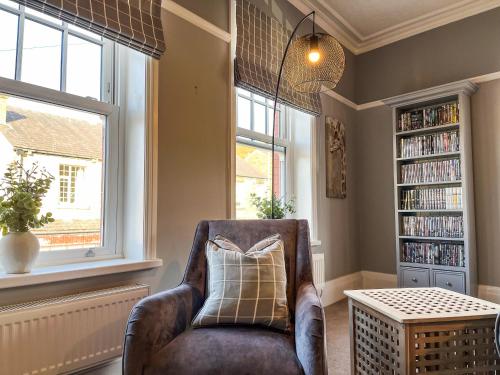 a living room with a chair and a book shelf at Cracken Cottage - Uk48297 in Chinley