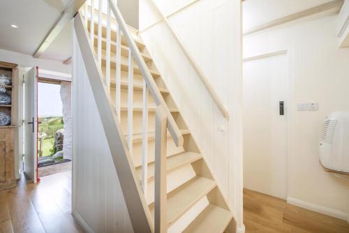 a white staircase in a room with a door at The Nant in Haverfordwest