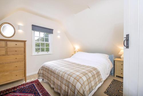 a bedroom with a bed and a dresser and a window at The Nant in Haverfordwest
