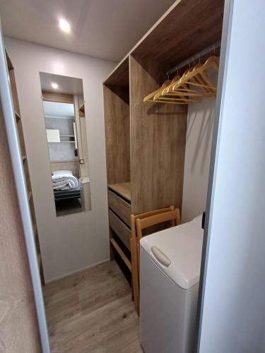 a small bathroom with a toilet and a mirror at Mobil home 6 personnes 3 chambres in Pont-Aven