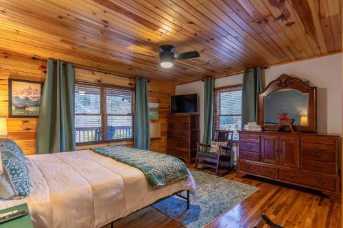 a bedroom with a bed and a dresser and a mirror at Riverbend Retreat in Todd