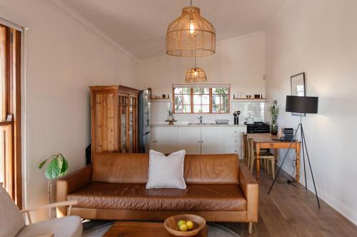 un salon avec un canapé et une table dans l'établissement Olyf guestcottage, à Bloemfontein