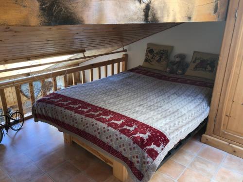 een houten bed in een kamer met een hemelbed bij Duplex au Col du Corbier in Le Biot