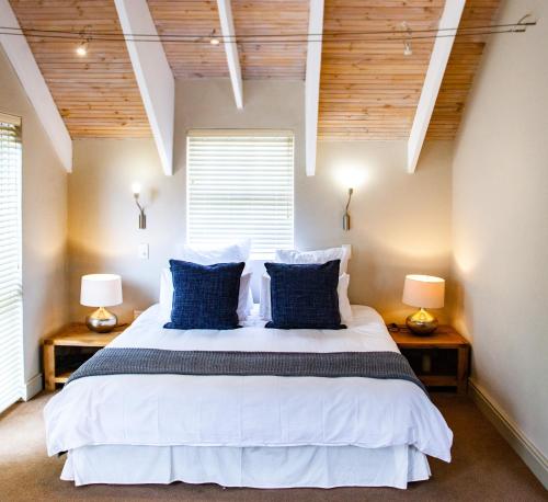 een slaapkamer met een groot bed met blauwe kussens bij SableChateau Beachfront Guesthouse in Stompneusbaai