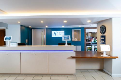a bar in a pharmacy with blue walls and a counter at Holiday Inn Express Birmingham Oldbury by IHG in Oldbury