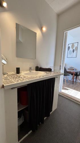 a kitchen counter with a sink and a table at Appartement confort deux Etoiles in Dole