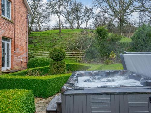 a hot tub in the backyard of a house at Old Upper Gwestydd in Highgate