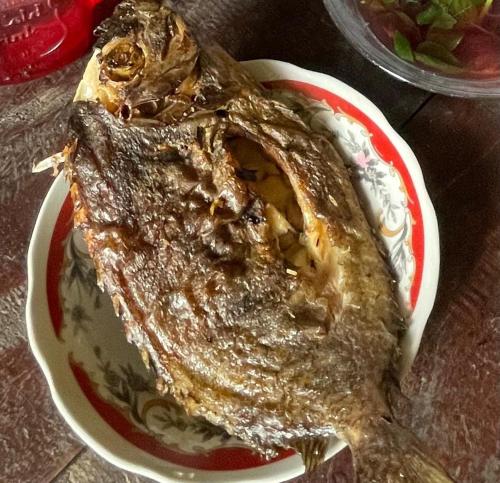 a plate of food with a fish on a table at The Driftwood House 