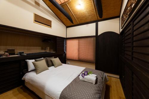 Un dormitorio con una cama grande y un escritorio. en Shiori 栞 京都, en Kioto