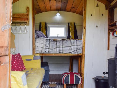ein Zimmer mit zwei Etagenbetten in einem winzigen Haus in der Unterkunft Shepherds Cottage - Uk49766 in Northampton