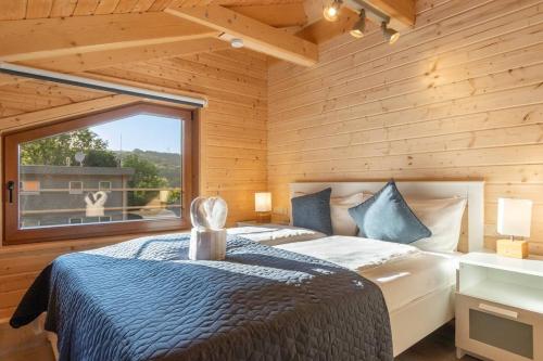 une chambre avec un lit et une grande fenêtre dans l'établissement Wellness-Chalet am Badesee für bis zu 10 Personen, à Rieden