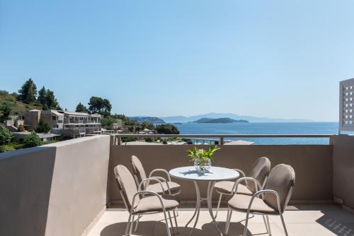 a balcony with a table and chairs and the ocean at Kassandra Bay Resort, Suites & Spa in Vassilias