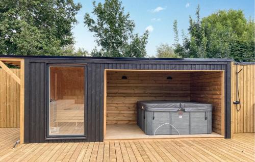 a black shed with a trash can in it at Awesome Home In Vinderup With Sauna in Vinderup