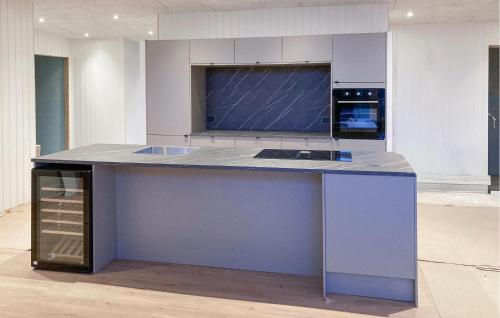 a kitchen with a blue island in a room at Awesome Home In Vinderup With Sauna in Vinderup
