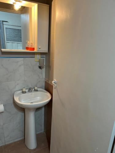 a bathroom with a white sink and a mirror at Cozy House Malbec Route piscina parrilla bici 2 dormitorios in Maipú