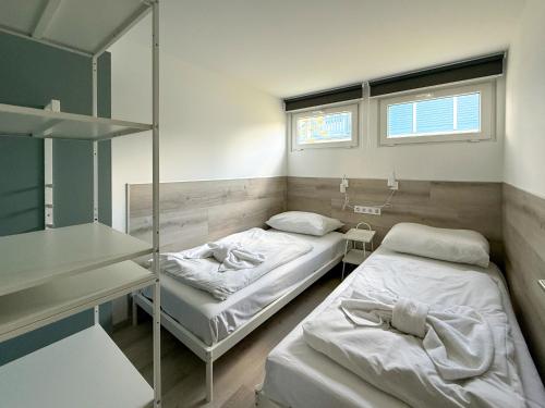 a room with two beds and a window at Aranypart Camping & Apartments in Siófok