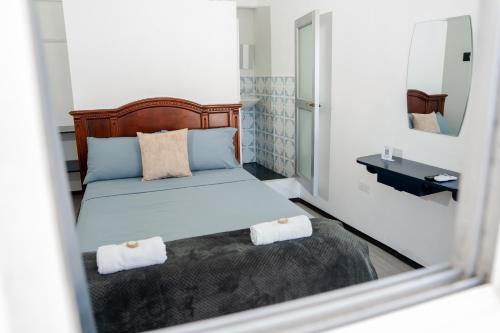 a bedroom with a bed with two towels on it at Hostal Elizabeth in Puerto Ayora