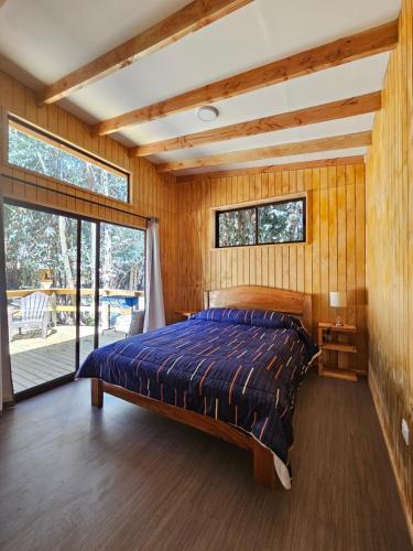 a bedroom with a bed and a large window at La Estancia del Molle in El Molle