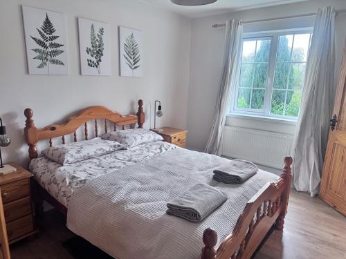 een slaapkamer met een bed met twee handdoeken erop bij Clones Town House in Feevaghmore
