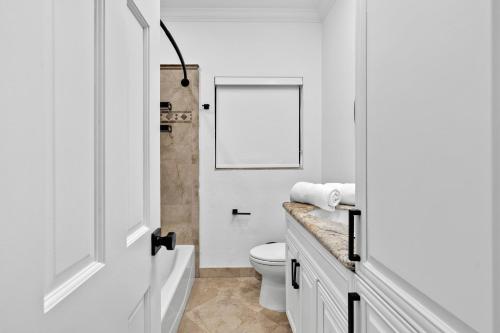 ポンパノビーチにあるVilla Heated Pool, Arcade games 5 min Beachのトイレと洗面台を備えた白いバスルーム
