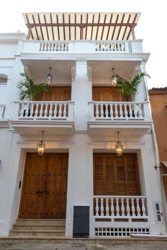 a white house with wooden doors and stairs at Hotel Casa Bianca by Faranda Boutique in Cartagena de Indias