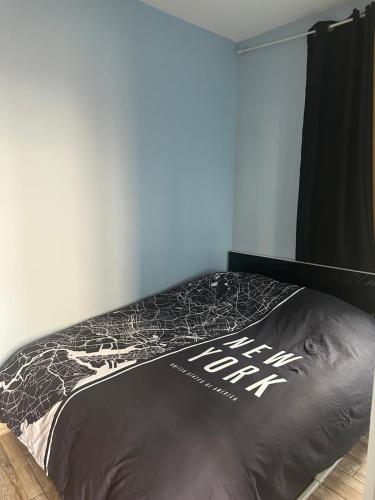 una camera da letto con un letto con un piumone nero di 2p plein centre d'Antibes, 500m Bord de Mer a Antibes