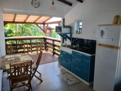 Il comprend une cuisine équipée d'une table, d'un réfrigérateur, d'une table et de chaises. dans l'établissement Ti kaz morne marigot, à Vieux-Habitants
