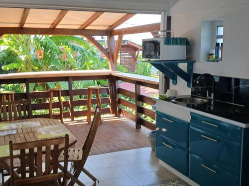 une cuisine avec un balcon équipé d'une table et de chaises dans l'établissement Ti kaz morne marigot, à Vieux-Habitants
