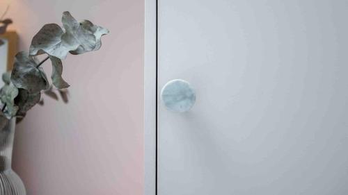 a vase with a plant next to a glass door at Suite Cosy Barbizon in Barbizon