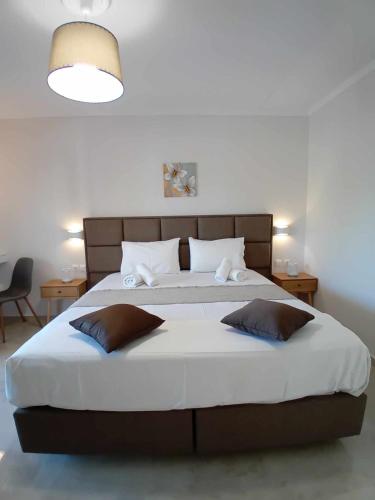 a bedroom with a large bed with two pillows at Roussa's Apartments in Laganas