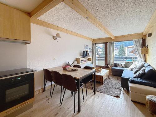 a kitchen and living room with a table and chairs at La tanière des Chamois 7p - proche piste Chalvet in Montgenèvre