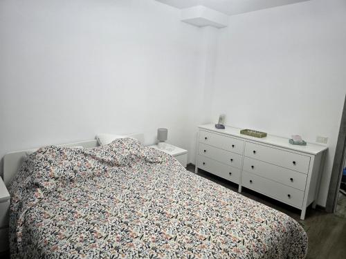 a bedroom with a bed and two dressers in it at Apartament Atlas in Popeşti-Leordeni