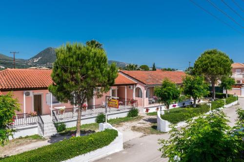 una fila de casas en una ciudad con árboles en Roussa's Apartments, en Laganas