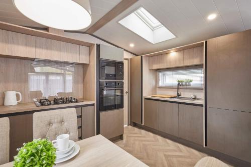 a kitchen with wooden cabinets and a skylight at Royal Pines Lodge with Hot tub in Allerthorpe