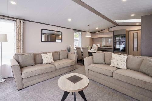 a living room with two couches and a table at Royal Pines Lodge with Hot tub in Allerthorpe
