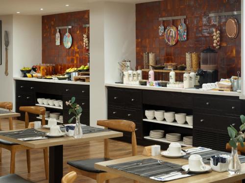 a restaurant with tables and chairs and a counter with dishes at H10 Ocean Dreams Hotel Boutique - Adults Only in Corralejo