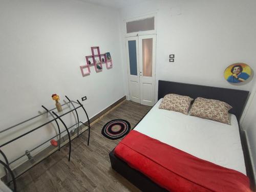 une chambre avec un lit avec une couverture rouge dans l'établissement Artistic Flat by Luxor Temple & Ancient Souq, à Louxor