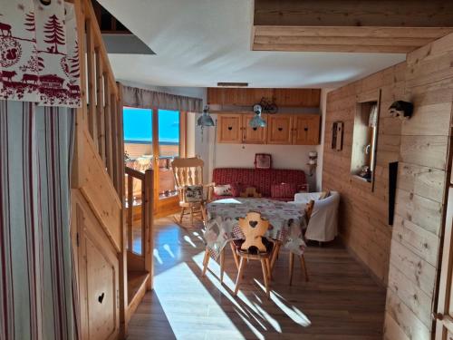 een woonkamer met een tafel en stoelen in een kamer bij Duplex au Col du Corbier in Le Biot