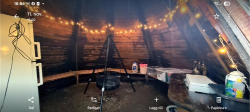 a dark room with a table and lights at Liten gårdshytte til leie in Åseral